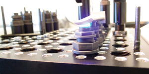 Photo of the Blue Photon universal fixture workholding system being used to hold a curved part for machining.