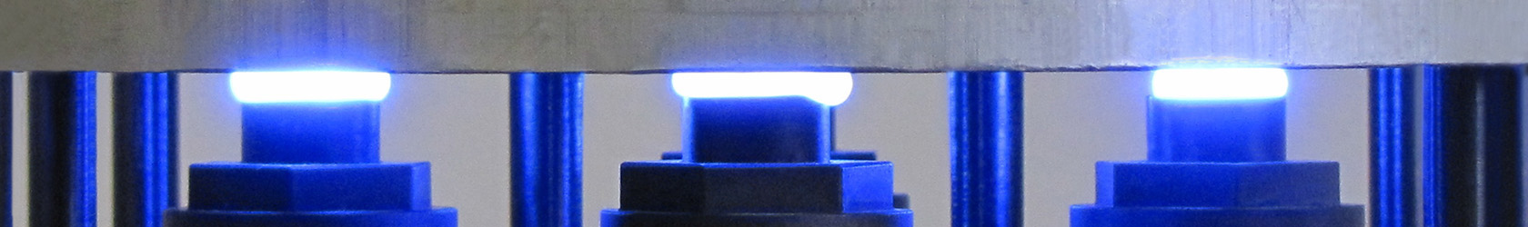 Photo of UV light curing Blue Photon Adhesive between a part and the gripper head