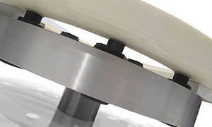 Closeup photo of a ceramic part affixed to a Blue Photon gripper using UV-activated adhesive
